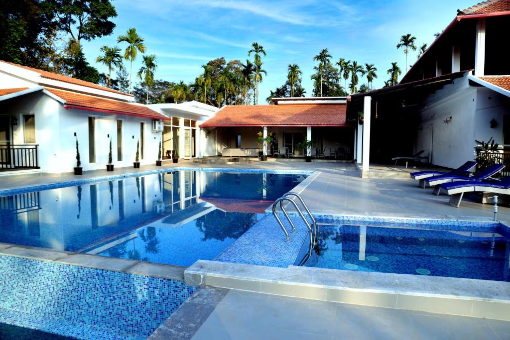 a swimming pool in the middle of a house at Tranquility Home Stay Coorg in Kutta