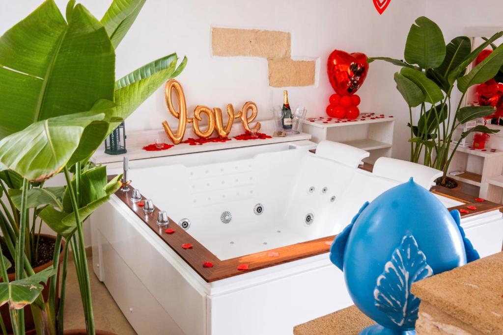 a bath tub in a room with plants at Nuvò-Lux e Spa in Veglie