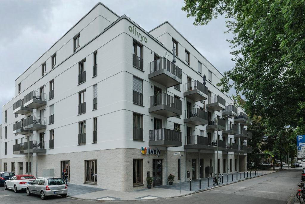 ein weißes Gebäude mit Balkon auf einer Straße in der Unterkunft LIVELY am Kaiserberg Duisburg in Duisburg