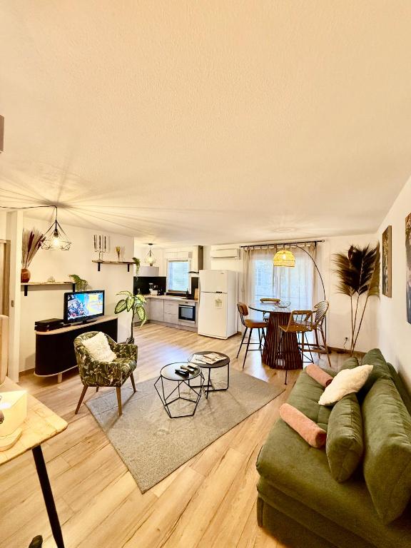 a living room with a green couch and a table at Suite appartement in Châteaurenard