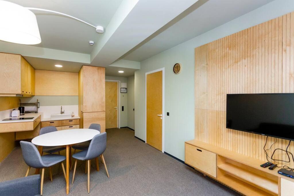 a room with a table and chairs and a tv at 1BR apart 1 min from M Kokhta 3rd floor in Bakuriani