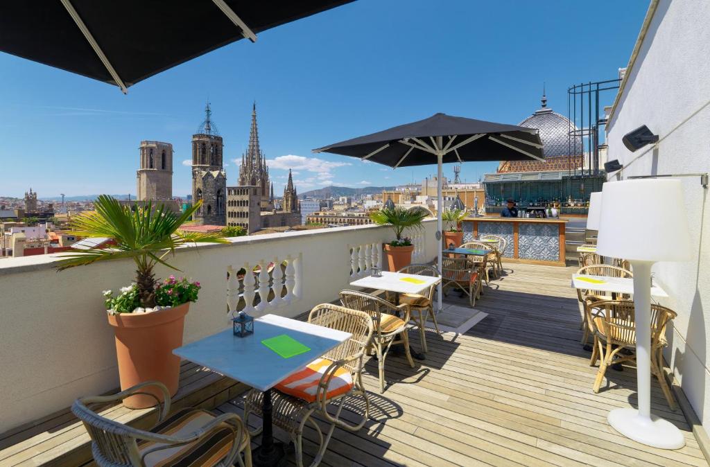 a balcony with tables and chairs and a view of the city at Boutique Hotel H10 Montcada in Barcelona