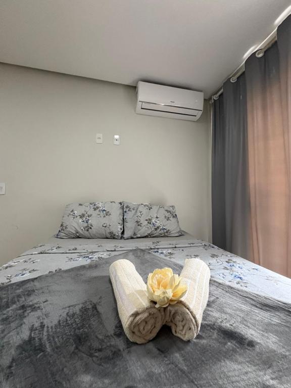 サンタ・クルース・カブラーリアにあるAp em Cor vermelha - perto do mar da cultura Pataxóのベッドルーム1室(花のついたベッド1台付)