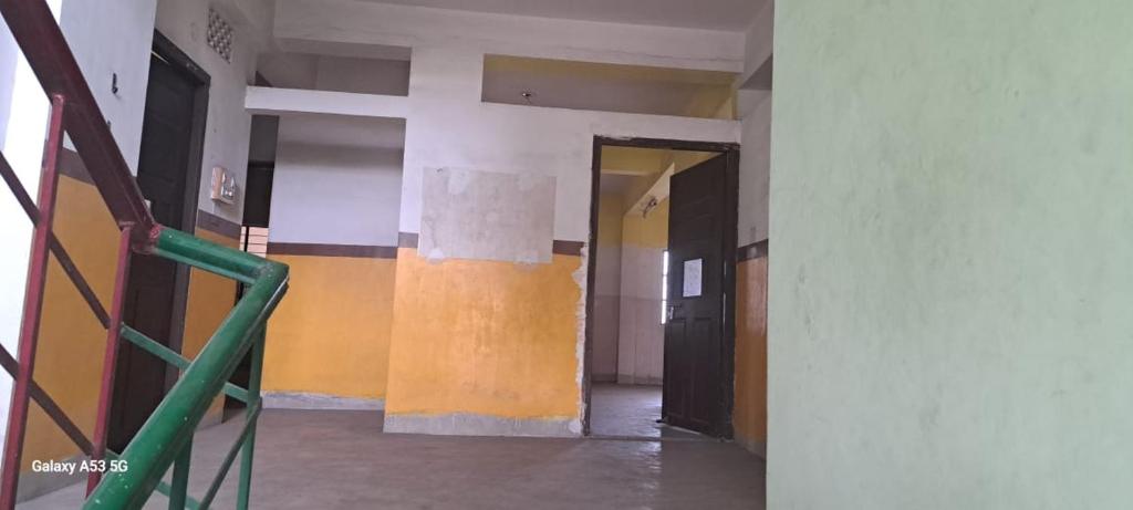 een lege gang van een gebouw met gele en oranje muren bij Maa Durga Apartment in Dhanbad