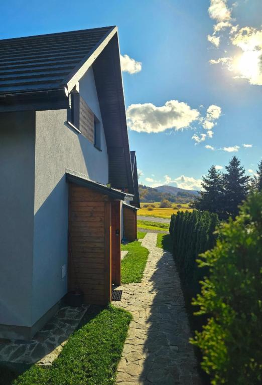 a house with a pathway next to a building at Domki Kamienne Zacisze in Uherce Mineralne (7)