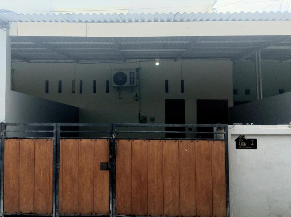 a building with a wooden gate in front of it at Homestay Room near Kuta & Legian Beach Bali in Pesanggaran