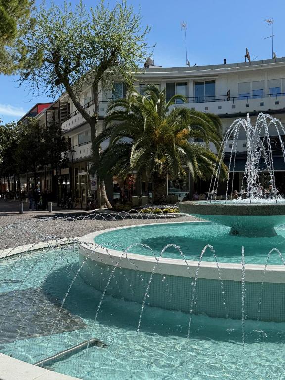 a pool with two water fountains in a city at Velar Apartment Suites in Lignano Sabbiadoro
