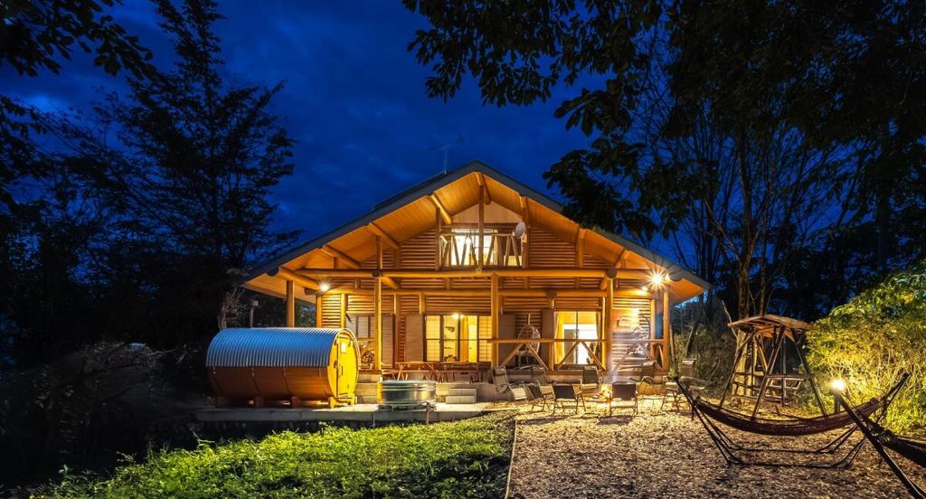 ein großes Holzhaus mit einem Wassertank in der Unterkunft 日本文化に触れる日光リゾート貸切Villa 最大10名 プライベートサウナ 雨でもBBQ にぎわいOK 完全プライベート空間 in Ochikawa