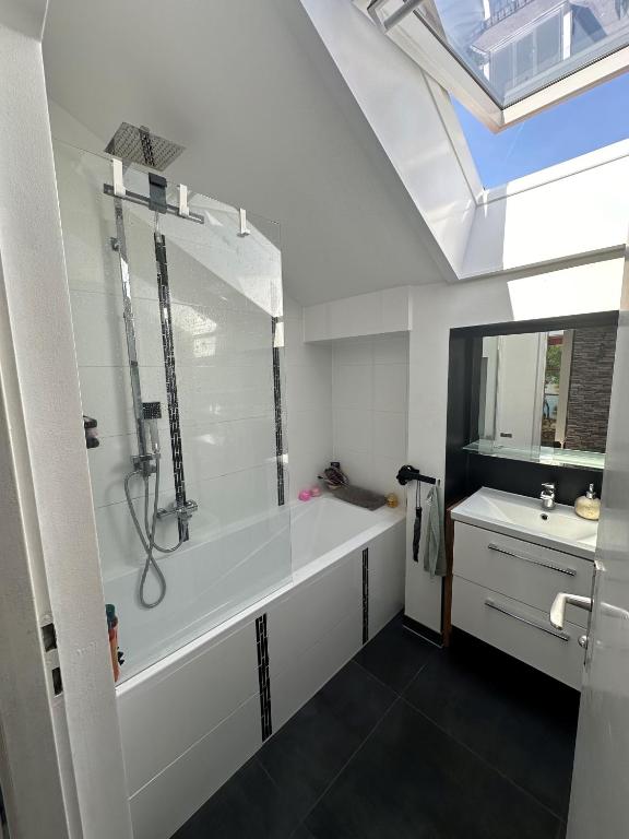 a bathroom with a bath tub and a sink at Heimat Apartment in Grafing