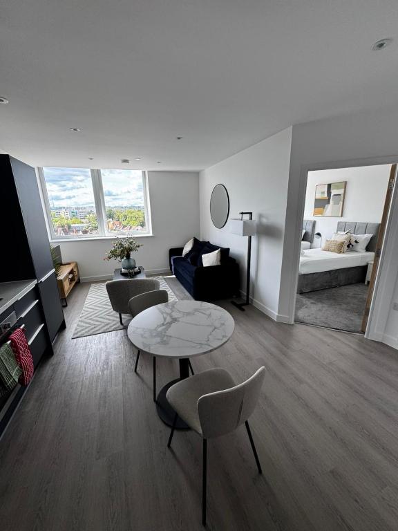 een woonkamer met een tafel, stoelen en een bank bij Stylish 1BR with Comfy Vibes in Beckenham