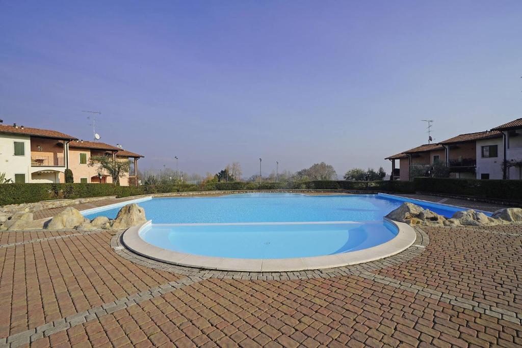 a large blue swimming pool in a brick yard at Blu Garda View in Polpenazze del Garda