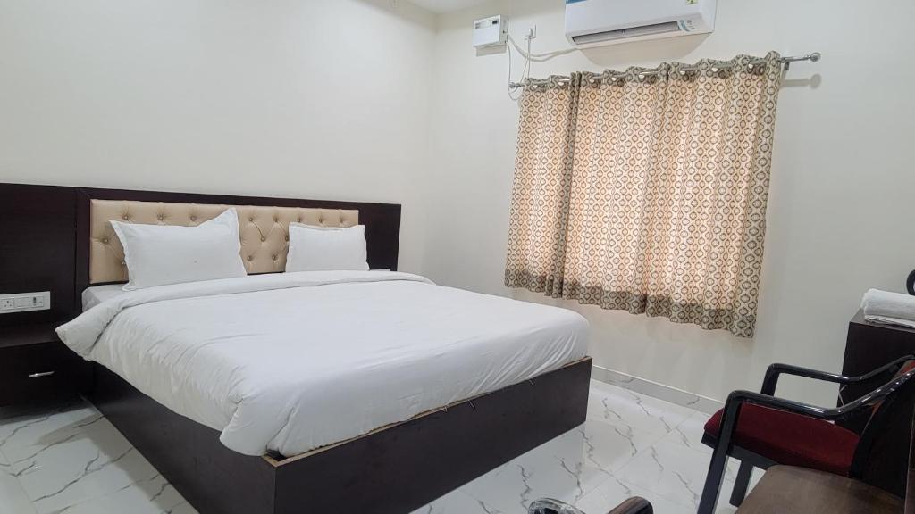 a bedroom with a large bed with white sheets at Samriddhi Homestay in Varanasi