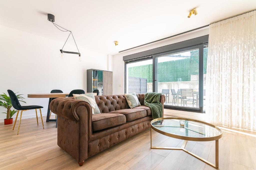 un soggiorno con un divano e un tavolo di vetro di La Casa Dorada a Santander