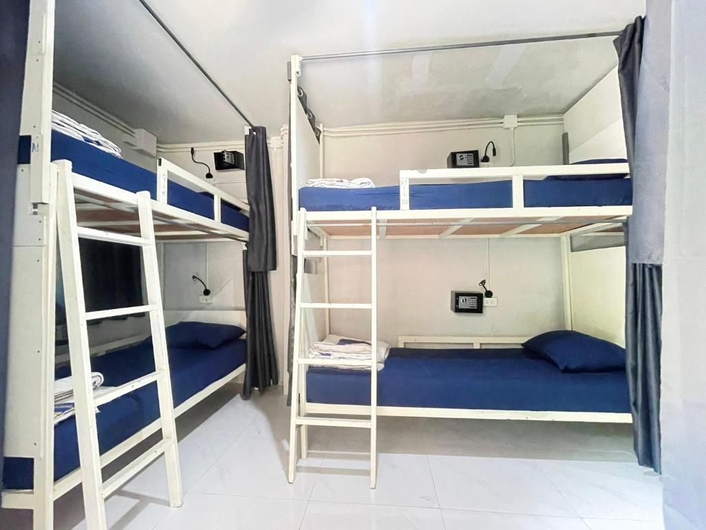 2 Etagenbetten in einem Zimmer mit blauer Bettwäsche in der Unterkunft Babyshark Hostel - Loh Dalum Bay in Ko Phi Phi