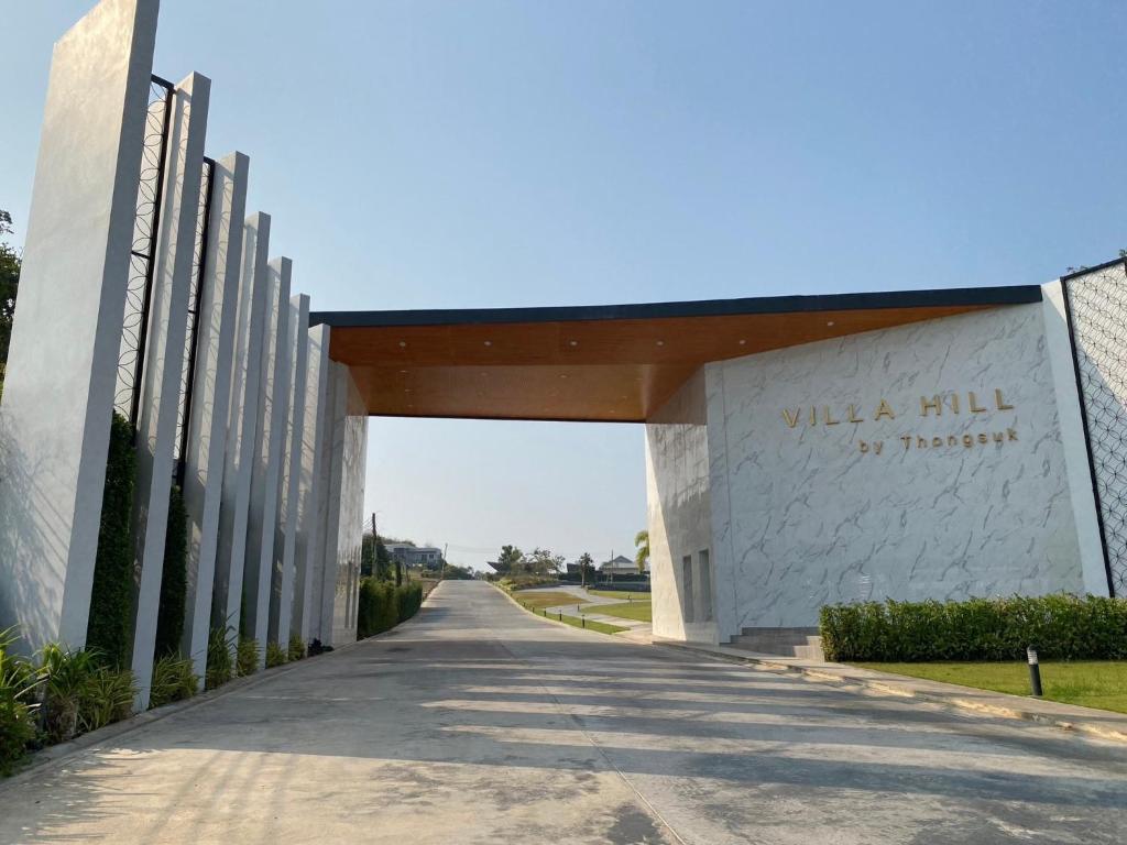 a road leading to a building with an archway at ทองสุข Pool Villa 3 ห้องนอน in Ban Huai Thalaeng Phan
