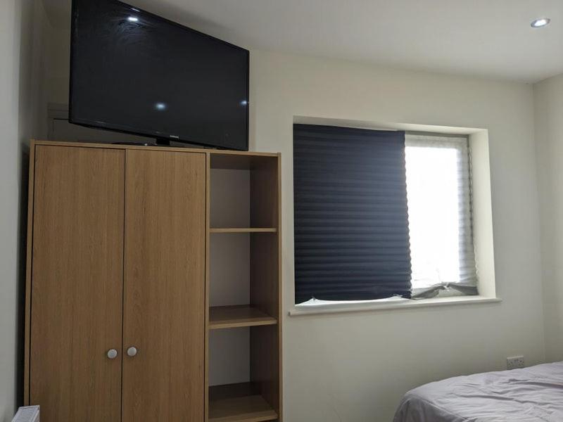 a tv on top of a cabinet with a window at Stylish Self Contained Unit - High Wycombe in High Wycombe