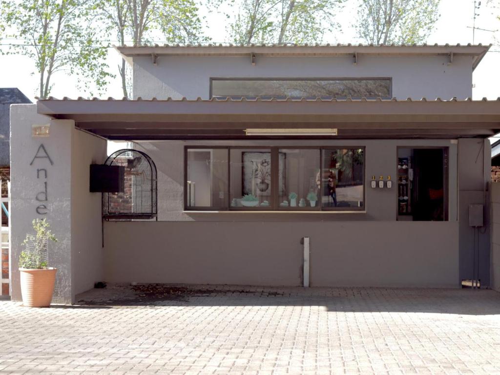a small white building with a large window at Andela Guesthouse in Bloemfontein