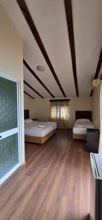 a room with two beds and a large window at Kaya by Keshtjella in Durrës
