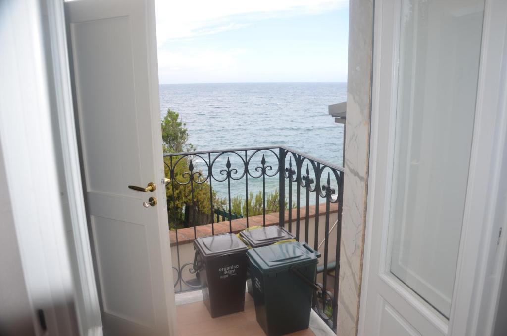 an open door to a balcony with two trash cans at Della Pace Apartment in Tellaro