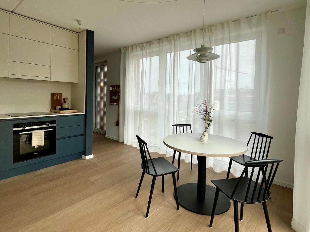 a kitchen and dining room with a table and chairs at Design Color Apartments Leer in Leer