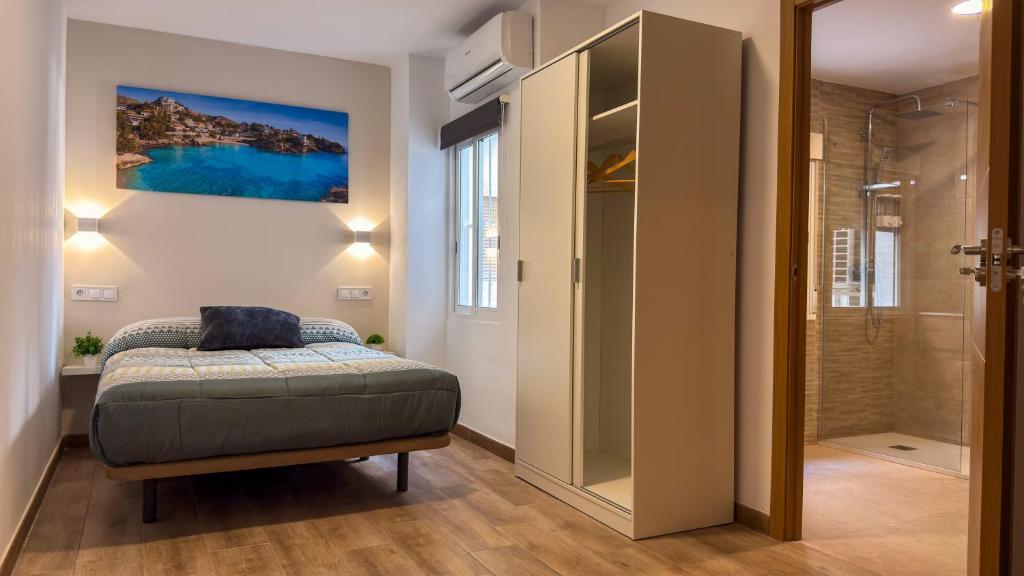 ein Schlafzimmer mit einem Bett und einer ebenerdigen Dusche in der Unterkunft Alc Homes in Alicante