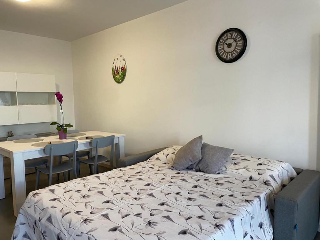 a bedroom with a bed and a desk and a clock at Appartamento Iris in Mori