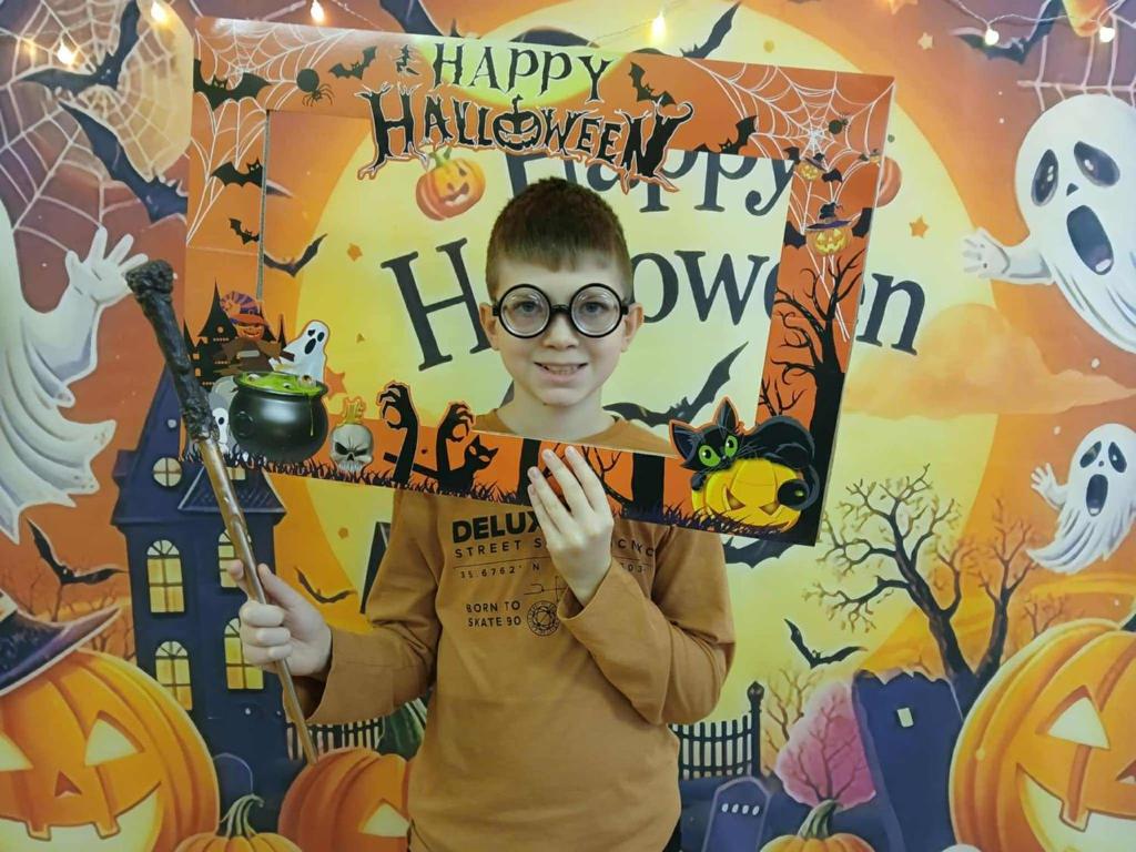 a young boy holding a sign that says happy halloweenflowflow at Penzión H1 in Humenné