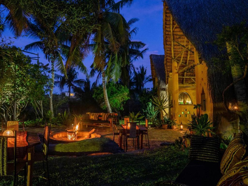 a patio with tables and chairs at night at Turtle Cove Self-Catering Lodge & Yoga Shala in Praia do Tofo