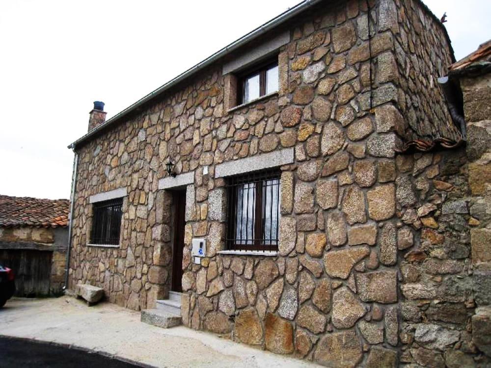 a stone building with a door and two windows at Escápate y desconecta en Son Soles! in Blacha