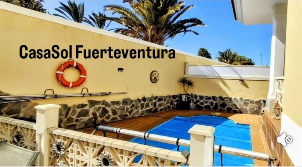un complexe avec une piscine devant un immeuble dans l'établissement Casa Sol Corralejo, à Corralejo