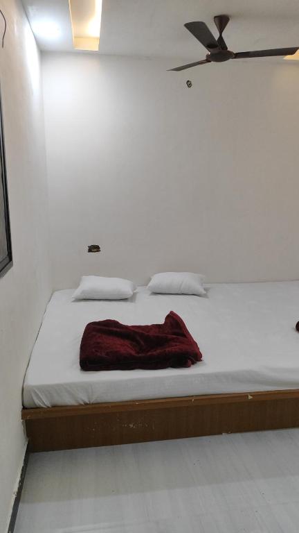 a bed with a red blanket on it in a room at SHRI VIJAYVEER PALACE in Ujjain