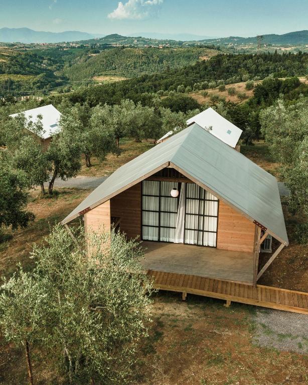 a small wooden cabin with a pitched roof at Glamping Poggio Nardini in Montelupo Fiorentino