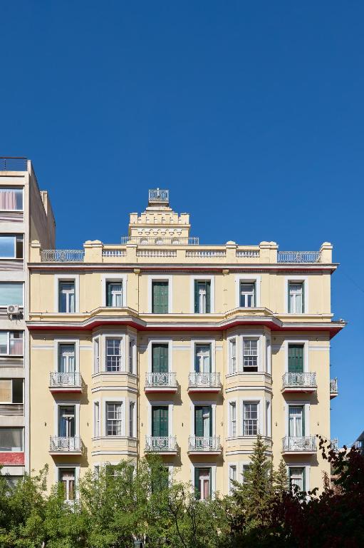 Un gran edificio con árboles delante. en Delphi Art Hotel by Prima Hotels, en Atenas