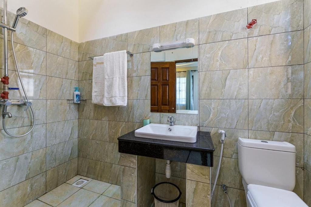 a bathroom with a sink and a toilet at Zuri's Tidehouse, With Beach Access in Mombasa