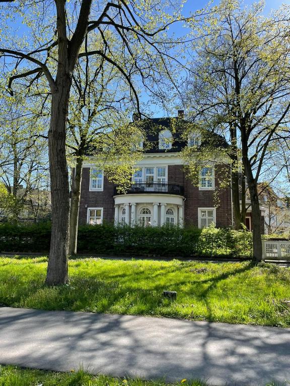 a large brick house with a tree in the grass at Nove Verde in Bremen