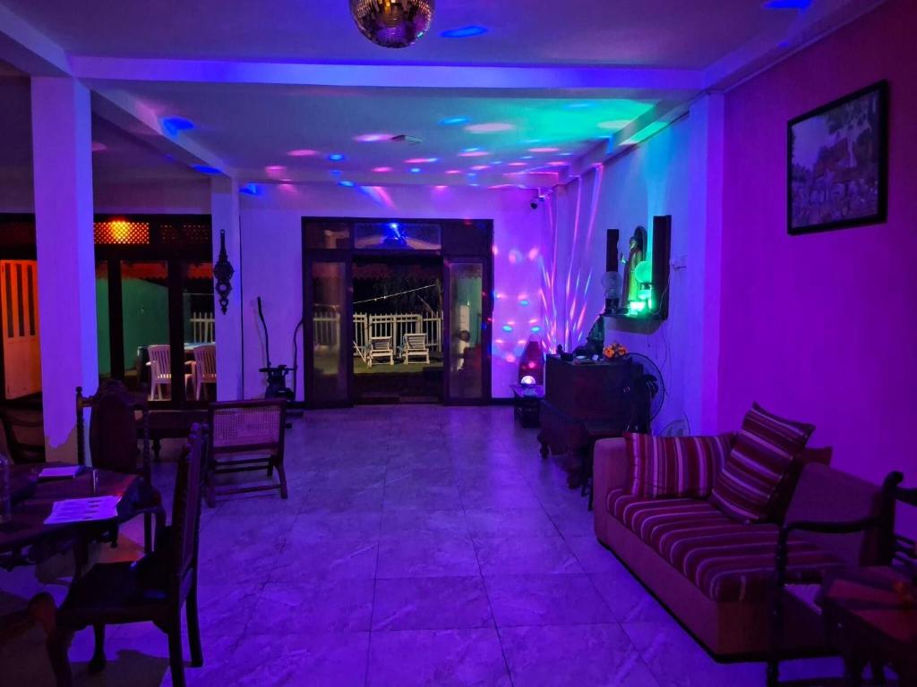 un salon avec des lumières violettes et vertes dans l'établissement Villa Camellia Garland, à Wenamulla