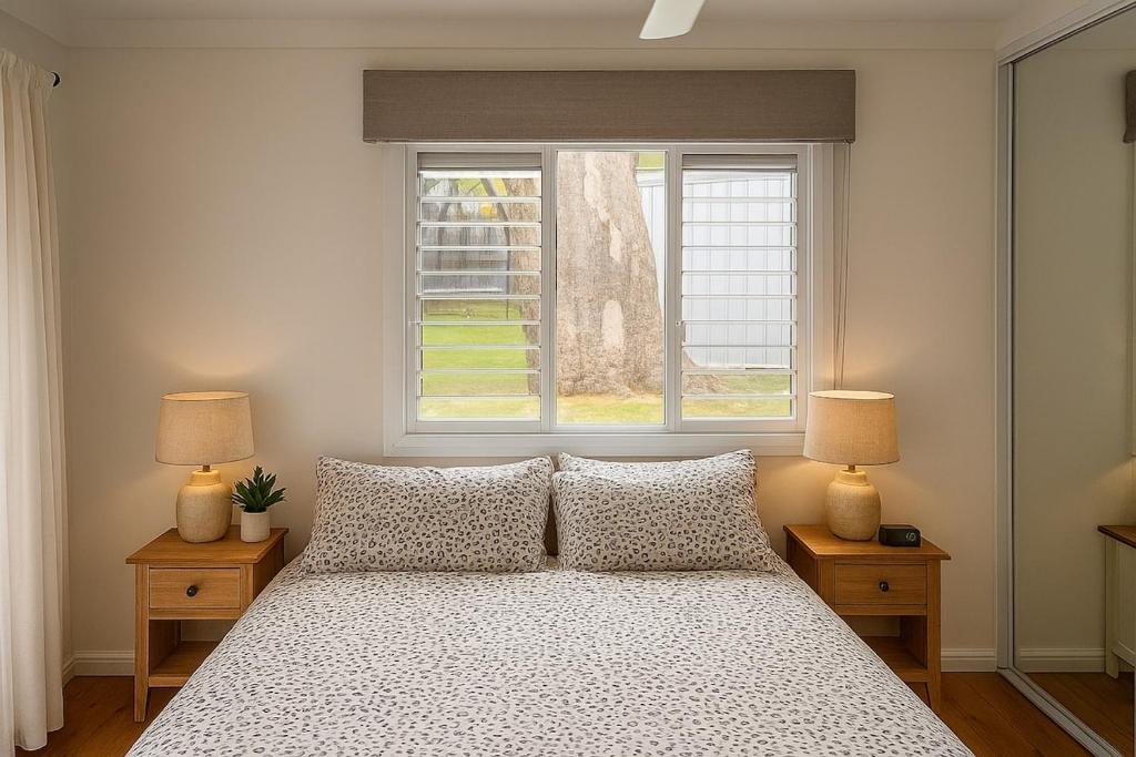 a bedroom with a bed with two lamps and a window at Relaxed Coastal Newport Getaway in Newport