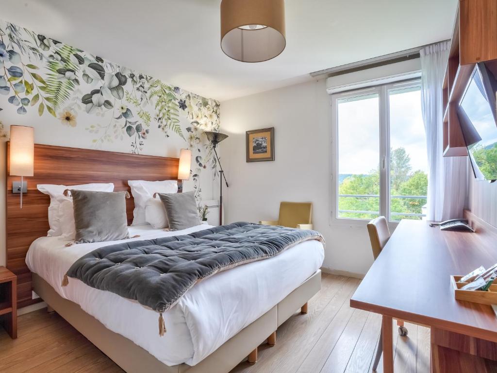 ビュール・シュリヴェットにあるResidhome Paris Saclay " Bures sur Yvette "の大きなベッドと机のある寝室