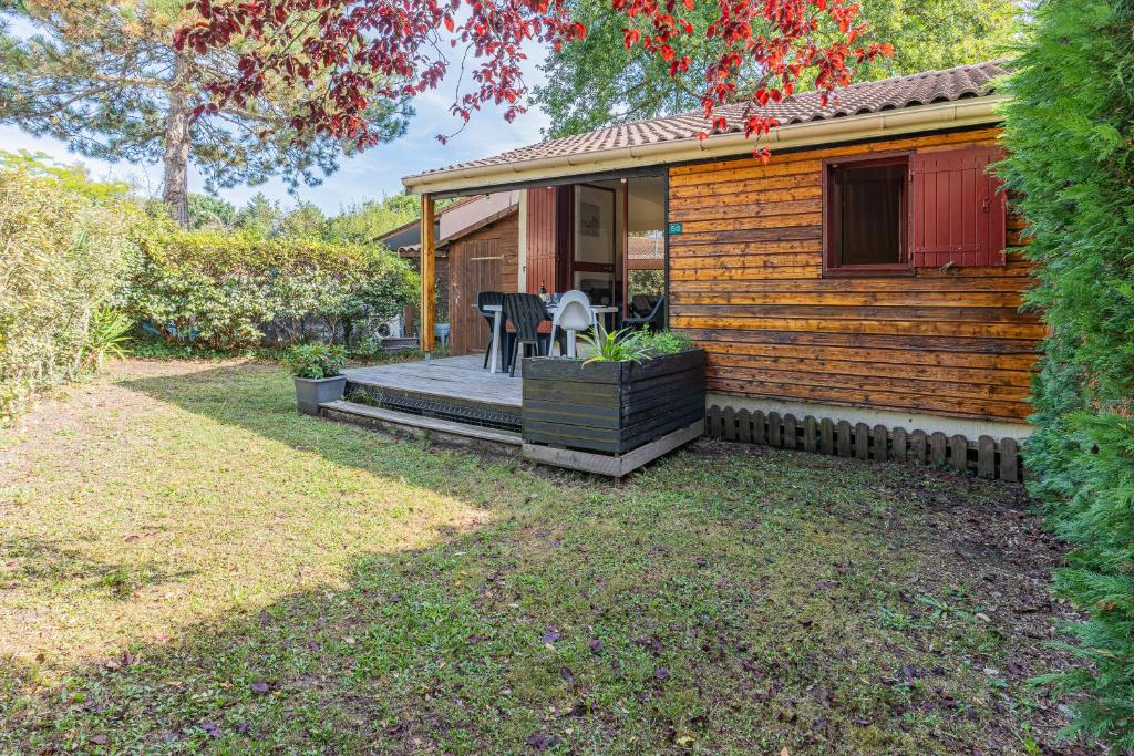a house with a porch with a table and chairs at Gite les Moussaillons in Hourtin