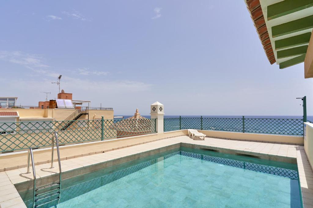 a swimming pool on the roof of a building at Beachfront apartment Torrox Costa in Torrox