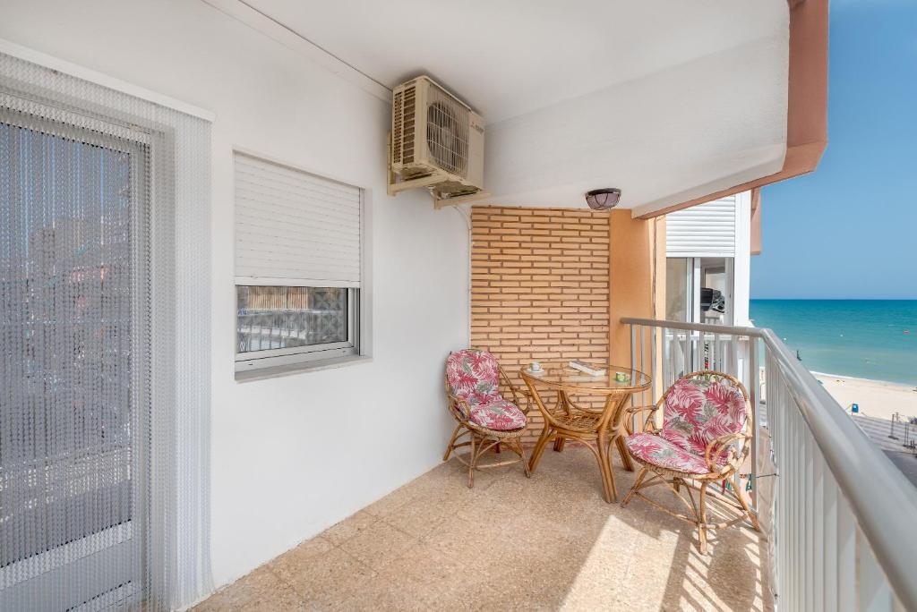 スエカにあるLa Torreta del Perellóのテーブルと椅子と海のあるバルコニー