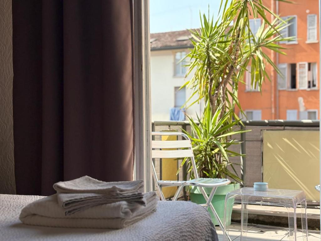 Una habitación con una cama y una ventana con una planta. en ForumGuestHouse Center Parking, en Parma