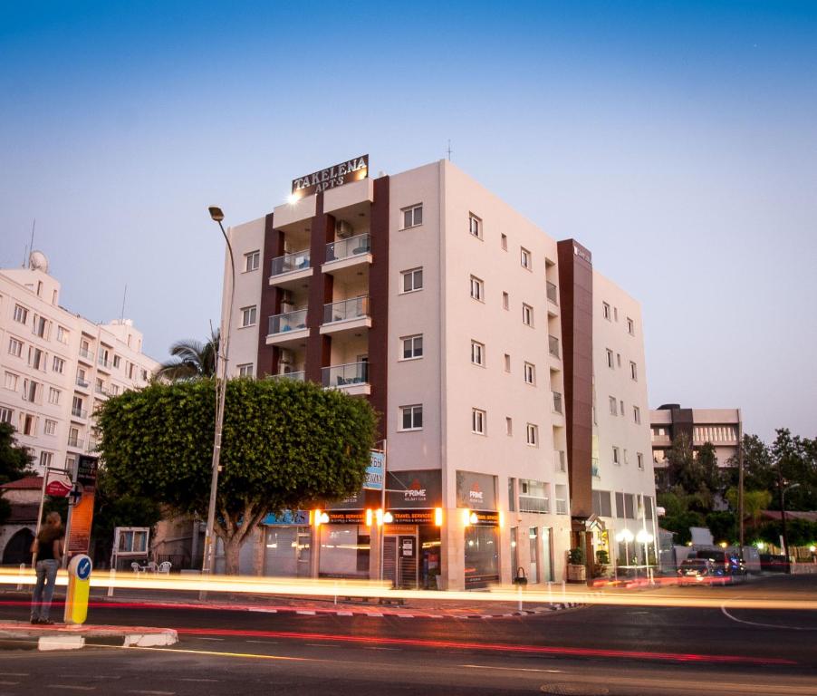 a white building on a city street at night at Takelena Apartments in Limassol