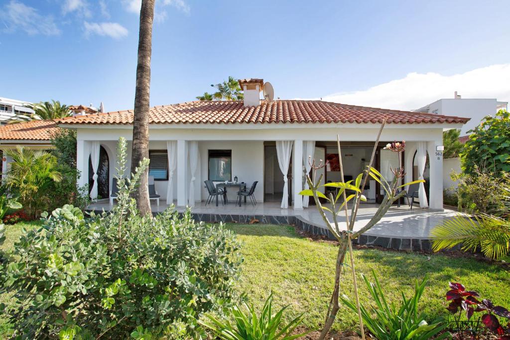 a house with a porch and palm trees at Sun Club Maspalomas in Maspalomas
