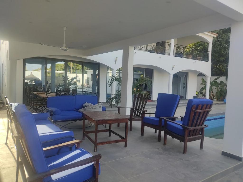 a patio with blue chairs and a wooden table at Premium Villa in Ngaparou between Saly Somone in Ngaparou