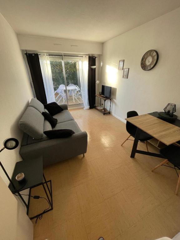 una sala de estar con un sofá y una mesa en Appartement Port d'Arcachon, en Arcachon