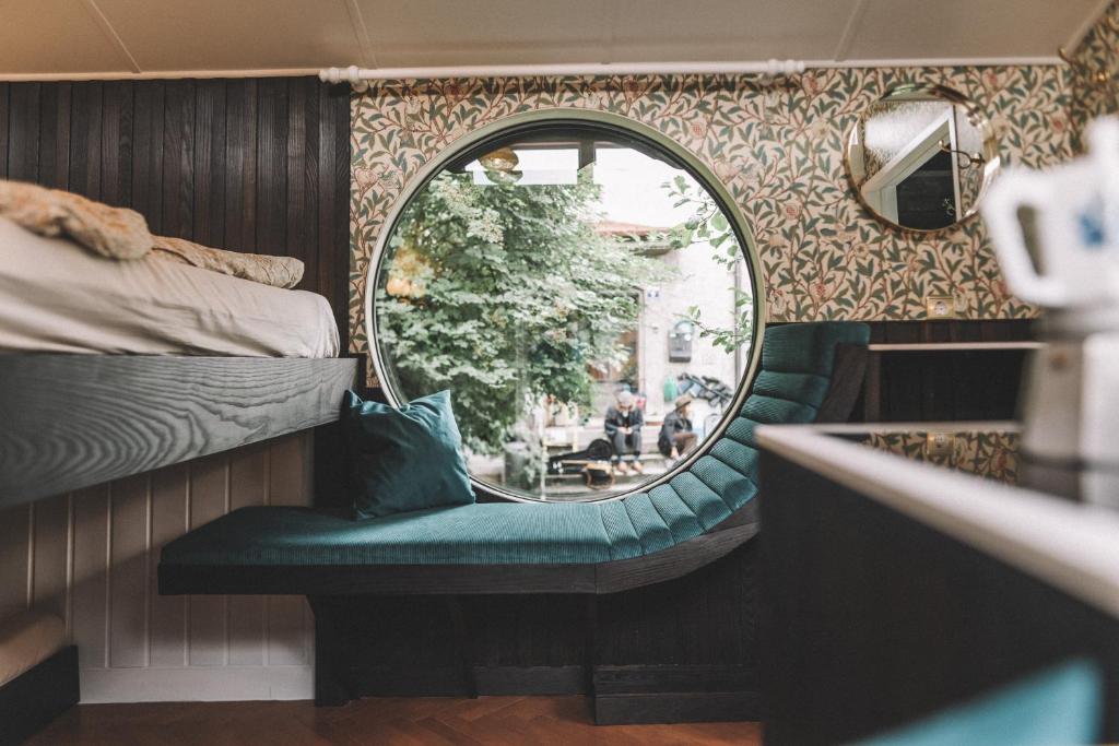 a mirror and a bench in a room with a bed at Camping Passeier Glamping Aurum in Saltusio