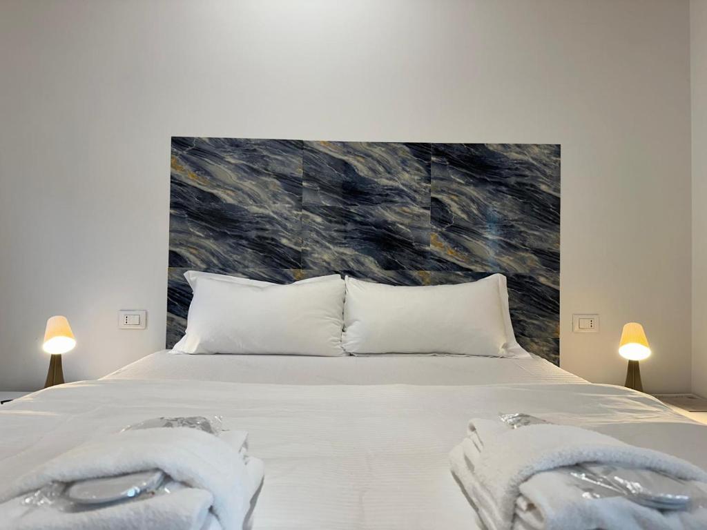 Un dormitorio con una gran cama blanca con toallas. en Welc-ōM Celeste Rooms, en Ponte di Brenta