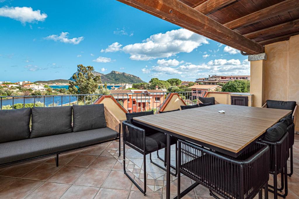 a patio with a table and chairs on a balcony at Residence Orizzonti 33 in Golfo Aranci
