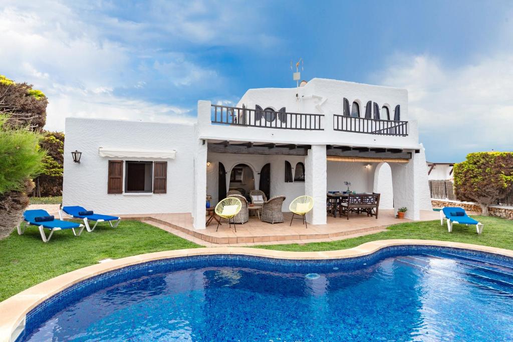 a villa with a swimming pool in front of a house at Alojamiento con encanto in Binibeca